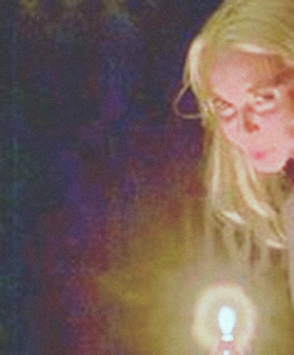 Lise by candlelight against gold-patterned wallpaper.